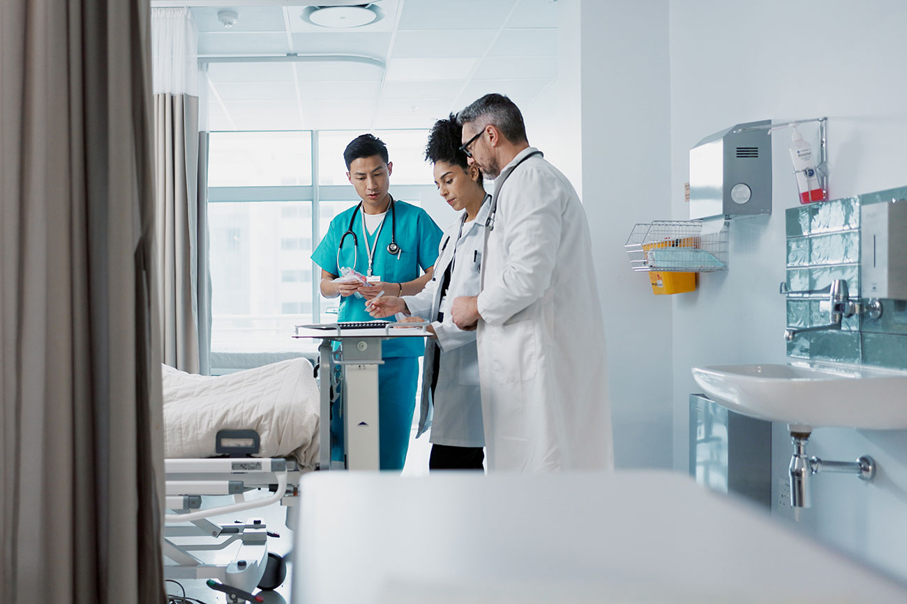 Physician reviewing a case with hospital OR staff Physician reviewing a case with hospital OR staff